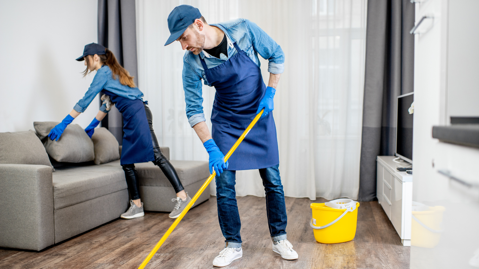Two professional workers cleaning a house efficiently as part of expert cleaning services.